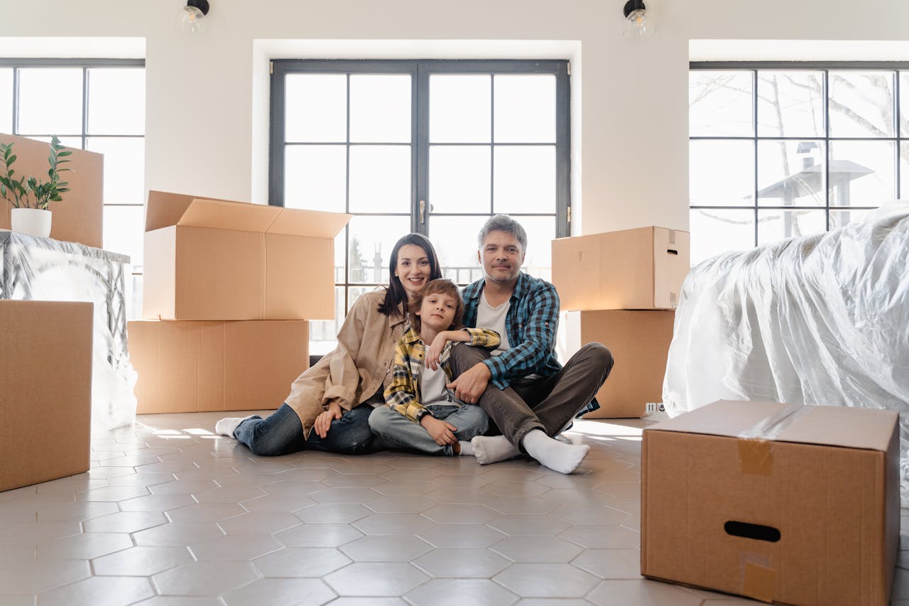services-01 A joyful family sitting together amidst moving boxes, marking a new beginning in their home.